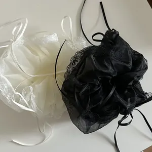 Detailed shot of large organza hair scrunchies with lace edges and long satin ribbons
