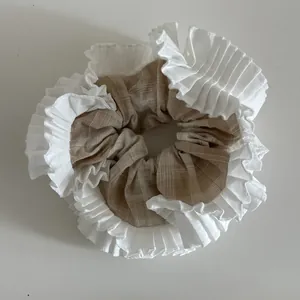 Dettaglio di un elastico a scacchi con bordo in pizzo bianco plissettato e elastico
