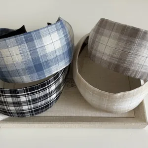 Détails de quatre serre-têtes en tissu à carreaux de couleurs variées sur un plateau
