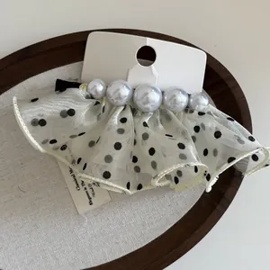 Détail de la pince à cheveux française en tulle à pois avec cinq perles dégradées
