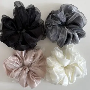 Close-up of four-piece set large organza scrunchies in black, grey, beige and cream colors