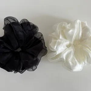 Close-up of elegant double-layered black and white pearlescent mesh fabric scrunchies