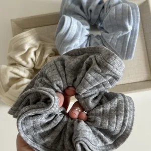 Lot de chouchous en maille côtelée crème, bleu clair et gris dans un plateau en tissu