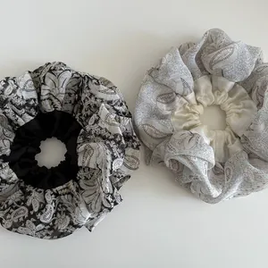 Close-up of oversized paisley chiffon hair scrunchies with satin pleated edge detail