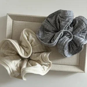 Chouchous en tricot crème et gris avec bords élastiques présentés dans un plateau chic
