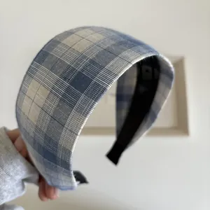 Gros plan d'un serre-tête à carreaux bleus avec design large et doublure antidérapante