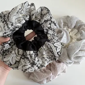 Macro shot of large paisley print scrunchies with satin stitching and pleated texture