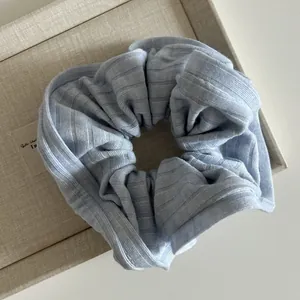 Détail du chouchou tricoté bleu clair montrant la texture douce du tissu côtelé