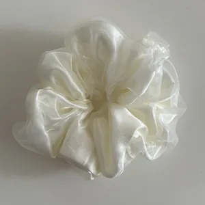 Detail of multi-layered pearl white organza scrunchie with soft pleated texture