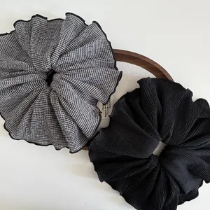 Classic black and gingham checkered oversized chiffon scrunchies on a wooden tray