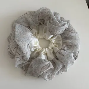 Detail of oversized paisley and cream satin double-layer scrunchie with ruffled texture
