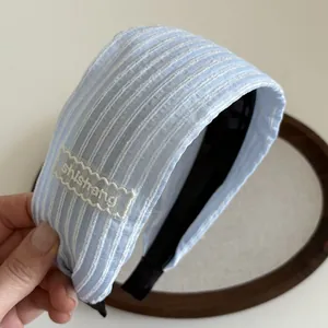 Vue détaillée du serre-tête large à rayures bleues avec dentelle et broderie