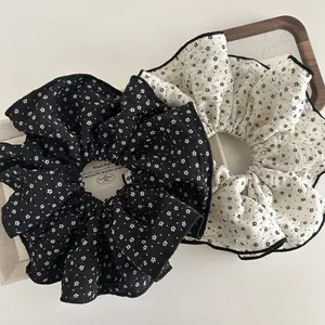 Close-up of beige and black star pattern scrunchies with elegant overlock stitch edges