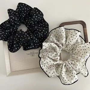 Detail of floral fabric scrunchies with white and black patterns in a wooden tray