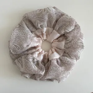 Detail of oversized floral scrunchie with pink satin and printed organza ruffles