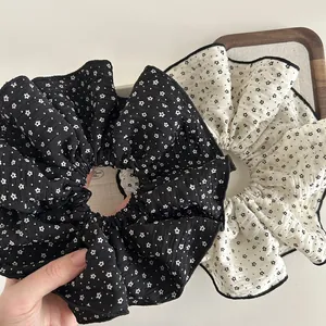 Floral large scrunchies set in black and cream with scalloped edges and puffy fabric texture