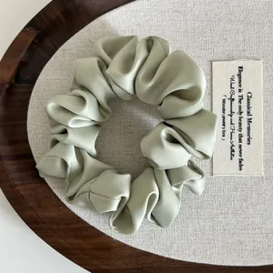 Primer plano de coletero de satén verde menta con pliegues elegantes y textura suave