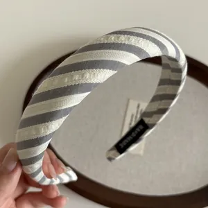 Gros plan du serre-tête en tissu rayé bleu et blanc avec étiquette faite main