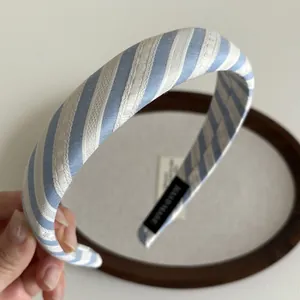 Détail du serre-tête rembourré à rayures bleu et blanc avec étiquette fait main
