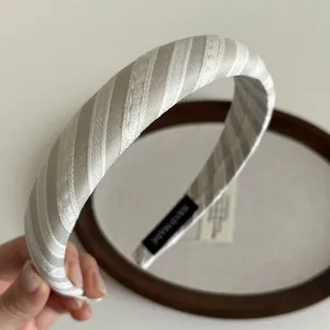 Gros plan détaillé du serre-tête rembourré rayé avec tissage en dentelle blanche