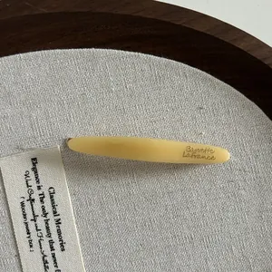 Gros plan sur la barrette en acétate crème avec le logo Barrette LaFrance gravé