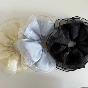 Trois chouchous géants en organza beige, bleu et noir avec des détails scintillants fins