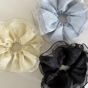 Vue détaillée de trois chouchous en organza avec paillettes en trois couleurs assorties