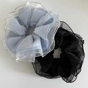 Détail de chouchous géants en organza bleu et noir avec texture à pois pailletés
