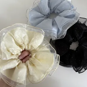 Détail de chouchous surdimensionnés en tulle à pois double épaisseur en bleu, crème et noir