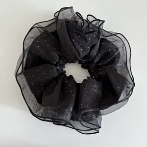 Gros plan sur chouchou géant en résille noire double couche avec paillettes argentées