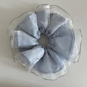 Détail du chouchou surdimensionné bleu clair double couche avec volants en organza
