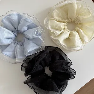 Détail de grands chouchous en tulle à paillettes en bleu, blanc et noir