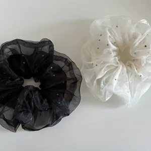 Détail de chouchous en organza à pois noirs et blancs avec texture en maille douce