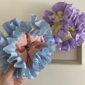 Dettaglio degli elastici arricciati a doppio strato con contrasti rosa-blu e viola-giallo