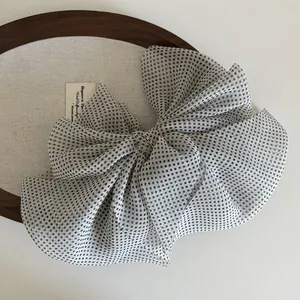 Close-up of translucent polka dot mesh bow hair clip with textured fabric details