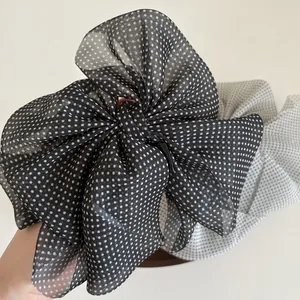 Elegant polka dot bow hair clip with mesh pearls on a minimalist background