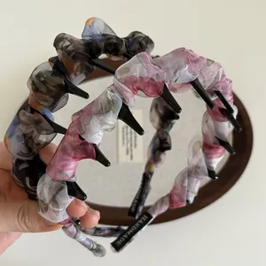 Gros plan du serre-tête plissé en mousseline fleurie avec clips et étiquette fait main