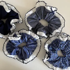 Set of four navy blue checkered hair scrunchies with white lace edges and bows