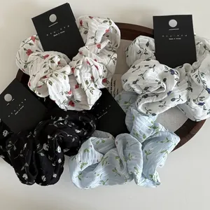 Set of four floral fabric scrunchies with Korean style patterns on brand display cards