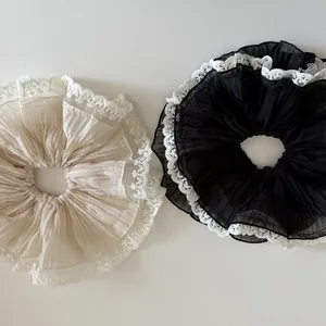 Detailed view of pleated chiffon hair scrunchies with intricate white lace edging