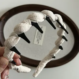 Close-up of cream woven fabric headband with black non-slip inner teeth for secure grip