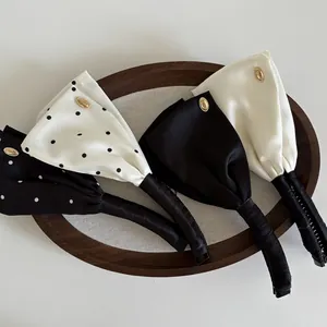 Set aus vier Satin-Bananenspangen in Schwarz, Weiß und gepunktet mit goldenem Metalldetail