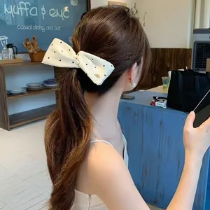 Polka-Dot Satin Haarklammer mit Schleife an gewelltem Haar im Café-Ambiente