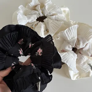 Close-up of pleated floral scrunchies with Lucky tag and ruffle edge details