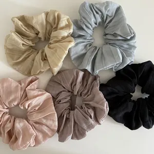Macro shot of five ribbed scrunchies in soft Morandi colors on white background