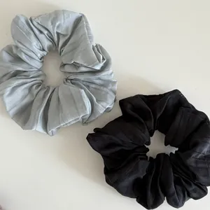 Detail of grey and black scrunchies set featuring soft pleated fabric texture