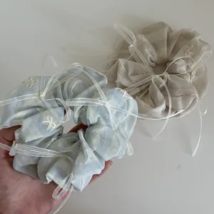 Détail de chouchous rayés avec broderie nœud blanc et rubans délicats élégants