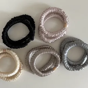 Detail of multi-color satin scrunchies set with silky pleated texture and elegant beads