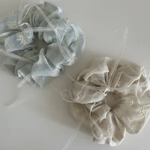 Chouchous rayés avec broderie de nœuds et rubans de soie en bleu et beige