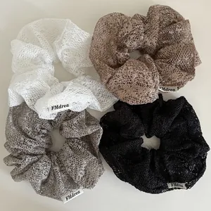 Set mit vier Spitzen-Haargummis in Weiß, Braun, Grau und Schwarz für Pferdeschwänze